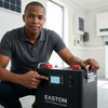 Man pointing at the display of a 51.2V 100Ah 5.12kWh LiFePO4 Rack Mount Battery in a modern setting.