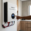 48V 100Ah Lithium-Ion Battery Wall Mount with user interface, wall-mounted in modern kitchen setting.
