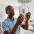Man installing a 96W Magnetic Ceiling Light LED Chip 34cm in a modern living room.