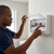 Person installing the 63A AC Inverter Power Box with Surge Protection to manage AC connections.
