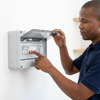 A person interacting with a 12-Way Electrical Distribution Box, ensuring proper electrical setup and safety.