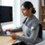 Woman using Electric Heated Massage Blanket while working at a desk with a computer.