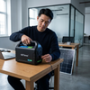 All-in-One Solar Power System 3.1Ah 4 LED Bulbs 12V - Man using GDTimes portable power station in an office setting with a solar panel in the background.