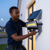 Man installing 30W Solar COB Flood Light PIR IP65 with solar panel for outdoor illumination.