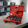 Water Tank Leak Detection Test Kit with pressure gauge, hand pump, hoses, and connection adapters in a red case.