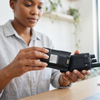 Person holding a 7.4V 1800mAh Li-Ion Battery Pack for a handheld device in a modern workspace.