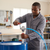 Man using a Manual Oil Transfer Pump to transfer fluid from a barrel in a workshop.