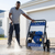 A person using a Gasoline Powered High-Pressure Washer for cleaning outdoor surfaces. Perfect for maintenance tasks.