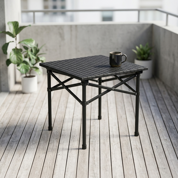 Folding Outdoor Table with Cross-Brace Frame on a balcony with a mug and plants.
