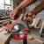 Cordless Circular Saw with Protective Blade Guard being used on wooden material in a workshop.