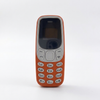 Compact Mini GSM Mobile Phone with Keypad in orange color, featuring a physical keypad and small display.