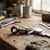 Metal Connecting Rod on a wooden workbench with tools and measuring caliper in a workshop setting.