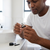 A man assembling a Metal Return Valve Assembly in a bathroom setting, focusing on precise mechanical components.