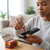Person inserting a battery from a box into a remote control with a pack of 1.5V AA Batteries 40 Pack visible.