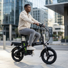 Man riding a Compact Electric Bicycle on a city street, showcasing its compact frame and electric assist features.