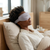 Adjustable Eye Sleeping Mask on a woman relaxing in bed for comfortable sleep and relaxation.