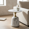 Modern Round Marble-Style Side Table with a marble top and gold pedestal base, next to a beige sofa.