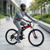 Person riding a VoltTrail Electric Cycling Bike in a modern urban setting.