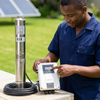 Man operating the 12V 9Ah Solar Water Pump System with stainless steel pump and control unit.