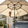 Woman standing under a 2 Metre Beach & Courtyard Umbrella in a stylish outdoor setting.