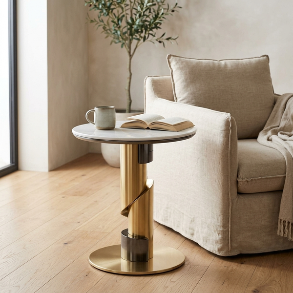 Round Pedestal Side Table in modern living room beside a cozy sofa, featuring a gold base and round marble top.