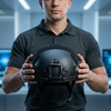 Person holding Combat Protection Headgear in a modern setting with technology in the background.