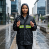Woman wearing One Size Rain Coat with Reflective Strips in the rain on a city street, showcasing its waterproof design.