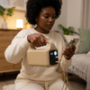 Woman using 50000mAh Portable Power Bank with Multiple Charging Ports to charge her smartphone.
