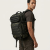 Man wearing a Sentinel Core Camouflage Daypack, showcasing its design and compartments for outdoor adventures.