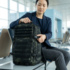 A person adjusting the Sentinel Core Camouflage Daypack in an airport setting.