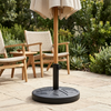 Round Outdoor Umbrella Base with Adjustable Pole Holder supporting an umbrella in a garden setting.
