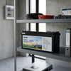 12.8V 150Ah LiFePO4 Lithium Battery displayed on a shelf alongside electrical tools and manuals.