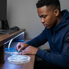 A person working with a 12V 10 Metres LED Strip Light Reel, measuring and preparing for installation.