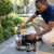 Man adjusting the 750W Automatic Water Pressure Pump with Gauge in a garden setting.