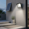 100W Solar LED Floodlight - Panel & Remote Kit mounted on a wall with a solar panel in the background.
