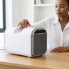 Smart Remote Control Portable Air Conditioner 220V on a table with a woman adjusting it.