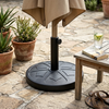 Round Outdoor Umbrella Base with Adjustable Pole Holder supporting an umbrella in an outdoor setting.