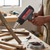 Heat Gun in use for heating wood, with metal nozzle and temperature settings visible, ideal for workshop applications.