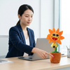 Dancing Musical Sunflower Plush Toy with Saxophone entertaining at a desk, featuring a woman pressing the button.