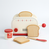 Wooden Pop-Up Toaster Playset with Breakfast Accessories featuring a toy toaster, wooden slices of bread, a jar of honey, and a butter knife.