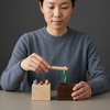 Wooden Magnetic Worm Catching Game Educational Toy with a child using a magnetic wand to catch colorful worms.