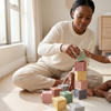 Mom and toddler playing with 12-Piece Squeeze & Stack Silicone Baby Building Blocks, stacking soft colorful blocks together.