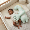 Soft Dinosaur Plush Toy with Long Arms cuddling with a sleeping baby in a nursery.