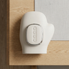 Cordless Heated Hand Massager resting on a wooden table surface, showcasing its ergonomic mitt-style design.