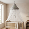 Hanging Nursery Mosquito Net Canopy with Pom-Poms over crib providing insect protection and a cozy sleeping space.