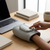 Person using a Cordless Heated Hand Massager at a desk beside a laptop and coffee.