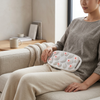 User relaxing on a sofa using the Large Area Vibrating Abdominal Massage Device for an abdominal massage experience.