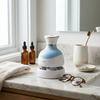 Electric Scalp and Head Massager on a bathroom countertop with wellness products and sunglasses.