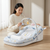 Portable Baby Lounger with Hanging Toy Arch in a cozy living room with a parent playing with the hanging toys.