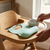Waterproof Soft Silicone Baby Bib placed on a high chair next to a bowl and spoon for easy mealtime cleanup.